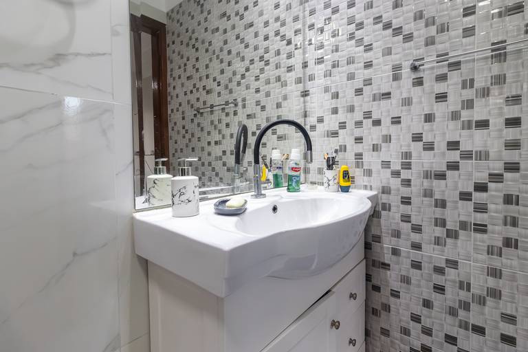 Fotografia imobiliária profissional na cidade de Praia Grande, SP, Baixada Santista. Fotógrafo especialista em imóveis Fernando Freire, para anúncio de imóvel em Airbnb, QuintoAndar e imobiliárias. Foto do ambiente do banheiro do apartamento na Vila Tupi.