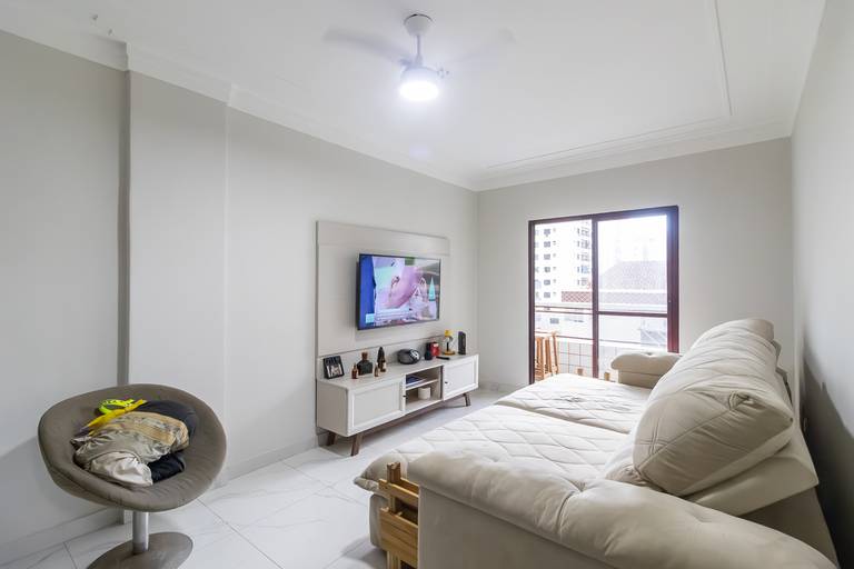 Fotografia imobiliária profissional na cidade de Praia Grande, SP, Baixada Santista. Fotógrafo especialista em imóveis Fernando Freire, para anúncio de imóvel em Airbnb, QuintoAndar e imobiliárias. Foto do ambiente da sala de um apartamento na Vila Tupi.