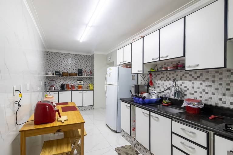 Fotografia imobiliária profissional na cidade de Praia Grande, SP, Baixada Santista. Fotógrafo especialista em imóveis Fernando Freire, para anúncio de imóvel em Airbnb, QuintoAndar e imobiliárias. Foto do ambiente da cozinha do apartamento na Vila Tupi.
