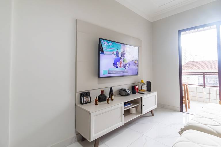 Fotografia imobiliária profissional na cidade de Praia Grande, SP, Baixada Santista. Fotógrafo especialista em imóveis Fernando Freire, para anúncio de imóvel em Airbnb, QuintoAndar e imobiliárias. Foto do ambiente da sala de um apartamento na Vila Tupi.