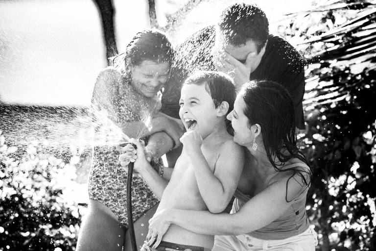 família tomando banho de mangueira