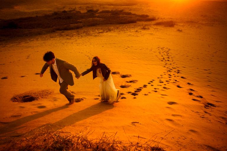 noivos subindo nas dunas