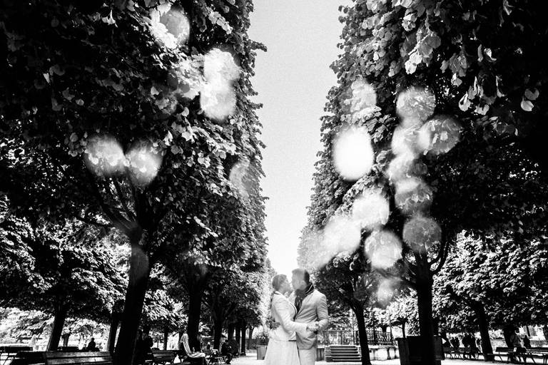 noivos se beijando no jardim ao lado da  Notre Dame em Paris