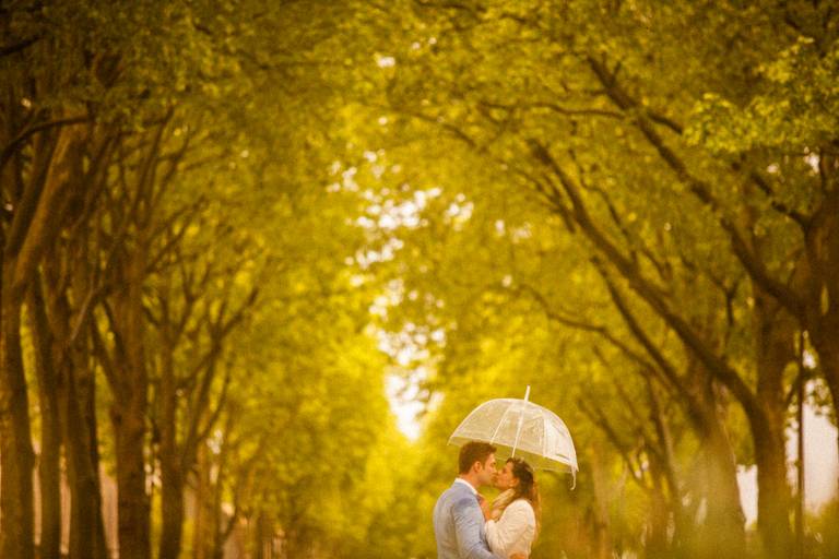 
casal se beijando em baixo do guarda chuva no chateau de versailles em paris