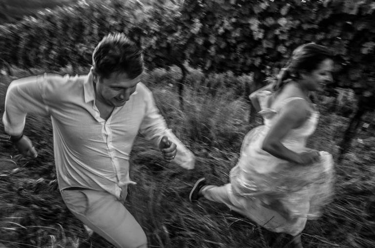 noivos correndo no vinhedo da vinícula Lídio Carraro