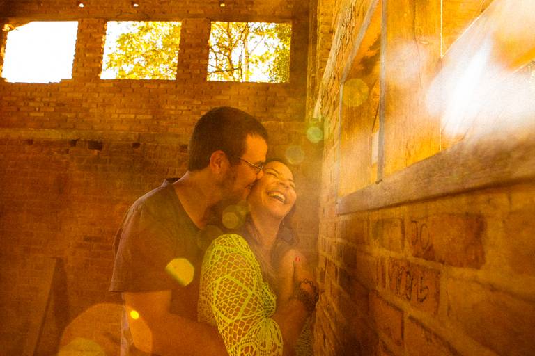 noivos dentro de ruínas com luz do sol invadindo