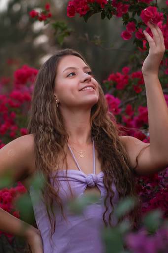 Modelo admirando flor em ensaio feminino Brasília feito pela fotógrafa Alexandra Paz