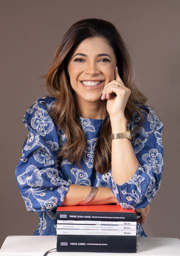 Ensaio corporativo Brasília
Alexandra Paz Fotógrafa 
Psicóloga especialista em psicanálise em pose discontraída com seus livros no estúdio minimalista.