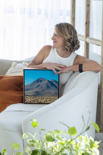 Ensaio corporativo Brasília
Alexandra Paz Fotógrafa 
Ensaio em estúdio com mobília leve e clean de uma fotógrafa de quadros Fine Art. Pose de perfil com destaque para uma de suas obras em moldura média.