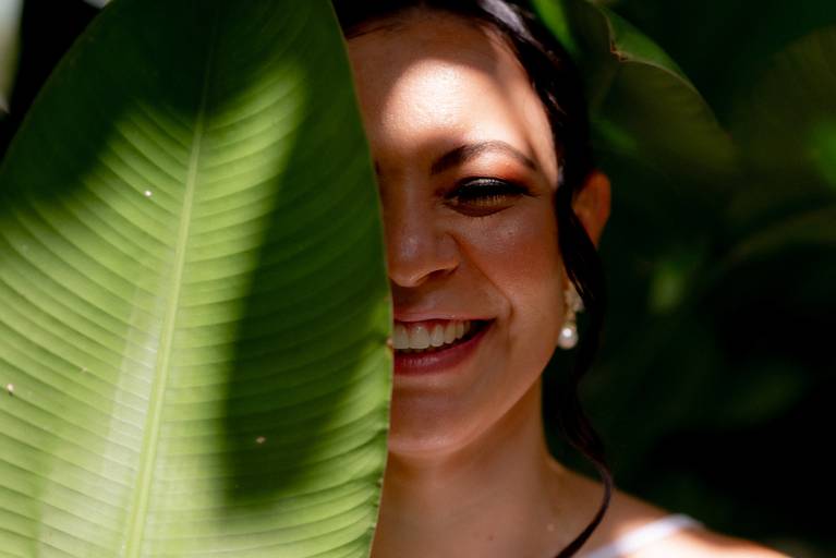 noiva com uma folha em seu rosto e sorrindo