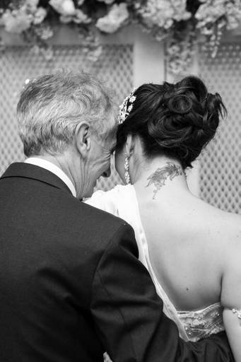 Foto estilo documental, que mostra um momento único entre pai e filha, antes de adentrarem a igreja, na cerimonia de casamento dela