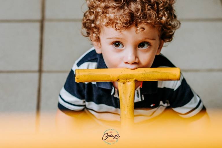 foto de menino lambendo apoio de gangorra
