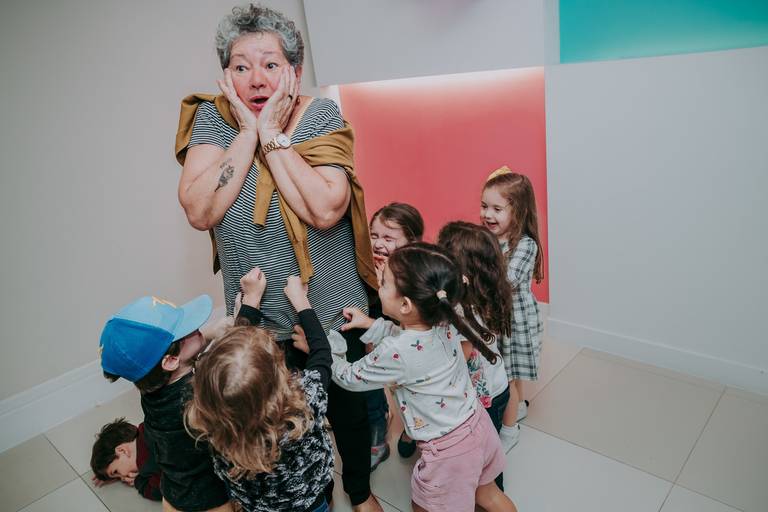 crianças cercam avó de aniversariante em brincadeira de pega pega e vo faz cara de medo 