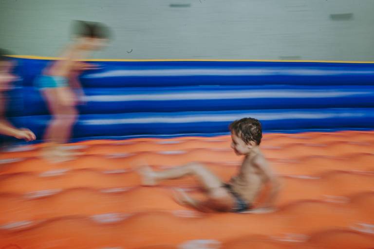 imagem propositalmente borrada de meninos escorregando em futebol de sabao