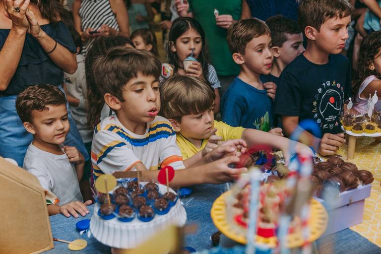 crianças atacam a mesa do bolo após o parabéns