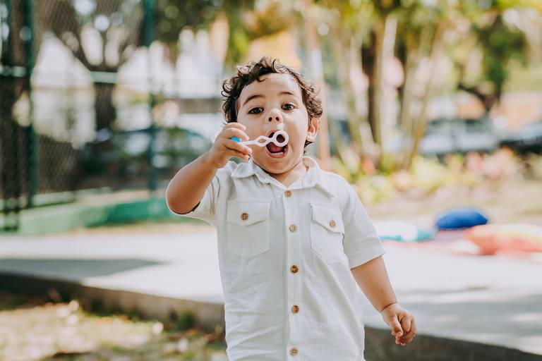 menino assuprando brinquedo de fazer bolinhas