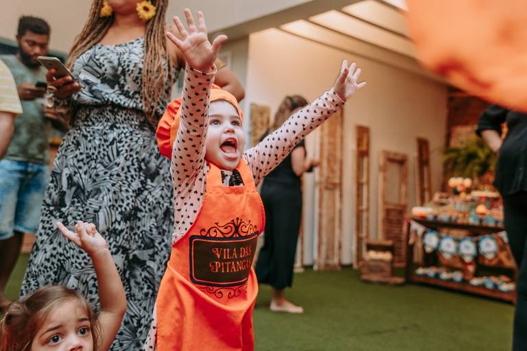 menina vribra de braços para o alto apos ganhar brincadeira na casa de festas vila das pitangas na tijuca