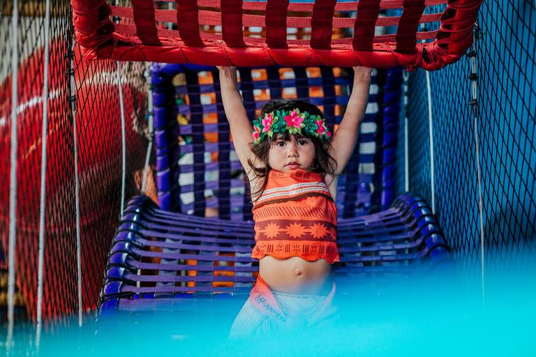 menina vestida de moana se pendura em brinquedao de casa de festas infantil vilarejo na barra da tijuca