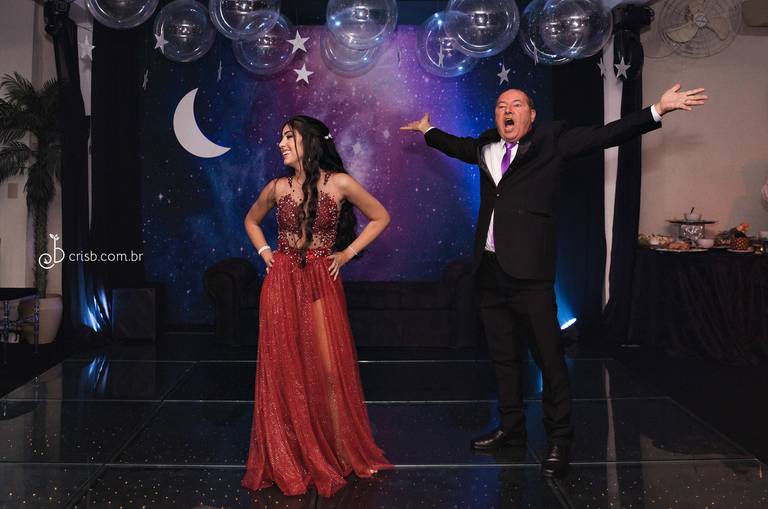 dança debutante pai entra em cena e de braços abertos, aniversariante com as mãos na cintura e sorrindo