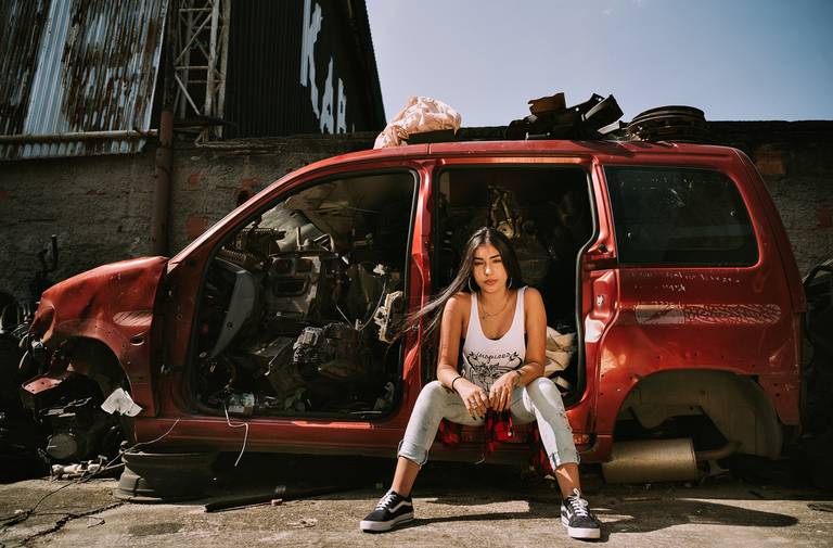 ensaio de debutante no ferro velho menina sentada na lateral do carro vermelho sem portas