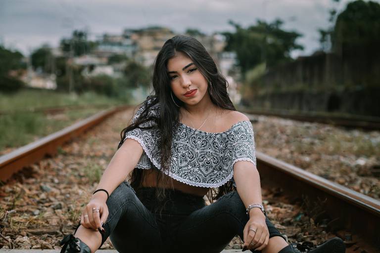 foto de menina de 15 anos sentada nas pedras da linha do trem