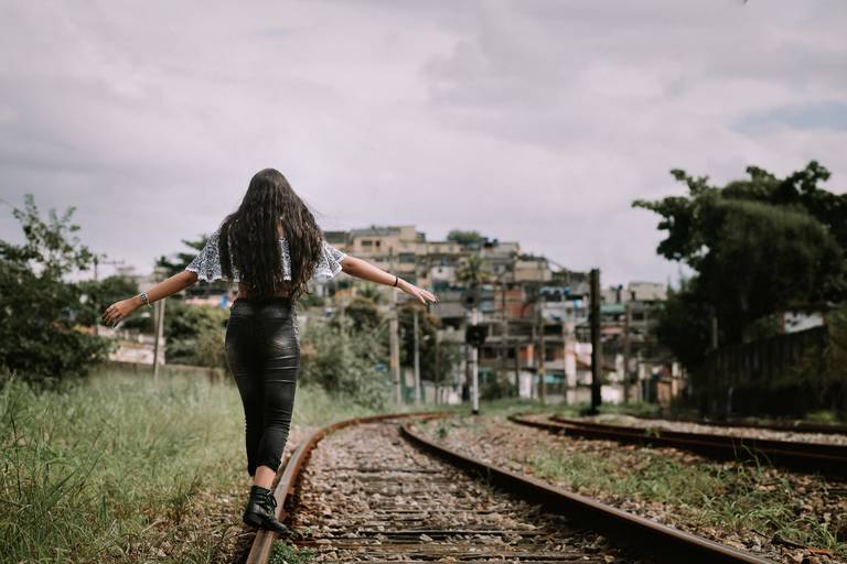 foto de menina caminhando de costas na linha do trem