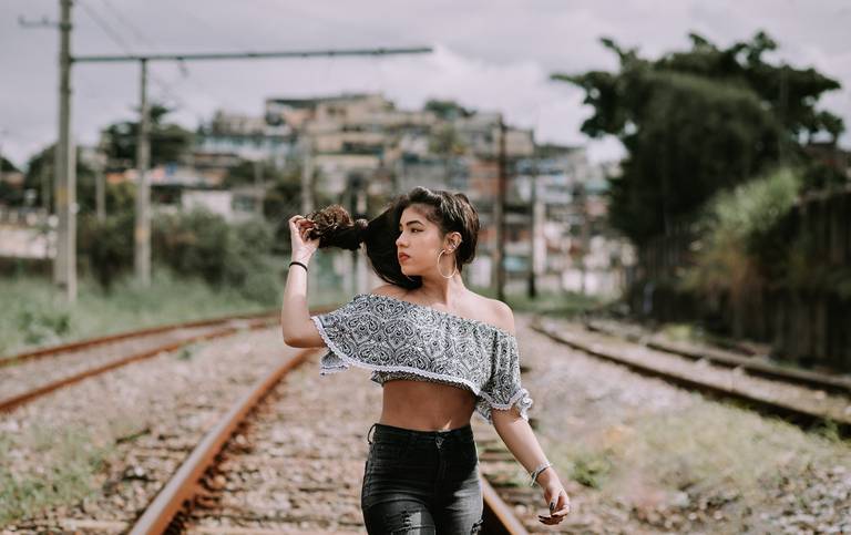 book debutante caminhando na linha do trem e soltando os cabelos ela olha para o lado direito