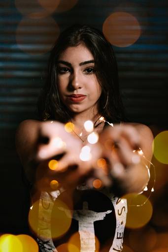 adolescente de 15 anos oferecendo luzes em bokeh para a camera
