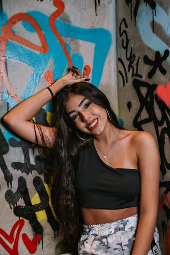 retrato de adolescente de 15 anos em frente a uma parede toda pixada