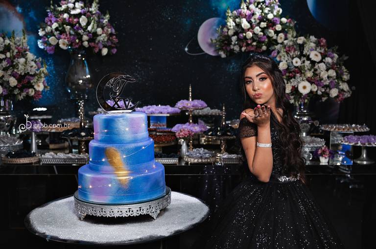 debutante mandando beijo pra camera ao lado de seu bolo com tema galáxias na casa de festas svm eventos em peidade no rj