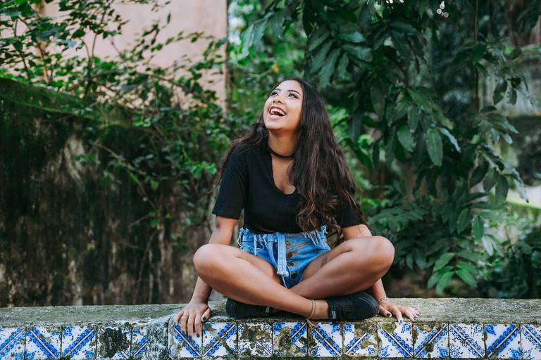 foto de debutante sorrindo sentada na posição chines no largo do boticário no rj