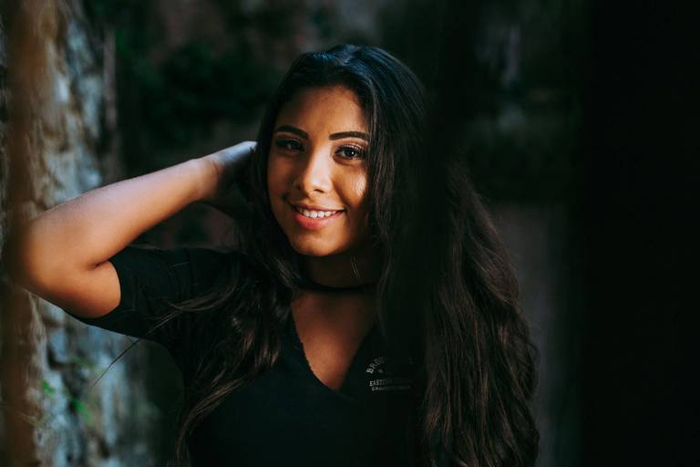 menina debutante com a mão direita no cabelo