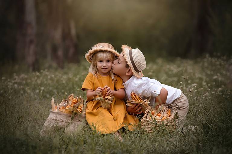 Hermanitos al atardecer en el campo. Flores y trigo en la sesión de fotos para Barby Massei de Santa Fe.