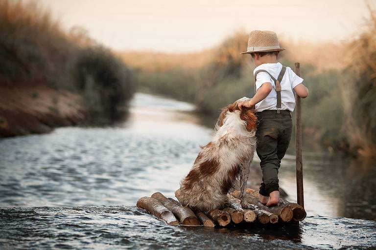 Niño en balsa de troncos sobre el río en Santa Fe. sesión de fotos con labrador al atardecer en San José de la Esquina