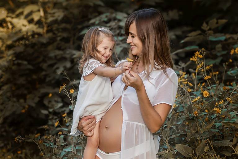 Disfrutando en el campo una hermosa tarde de verano, esperando con ansias la llegado de su hermanito. Vestidos blancos con coronas de flores en el bosque. Barby Massei Fotógrafa. Sesión maternity en el Santa fe. Flores amarillas.