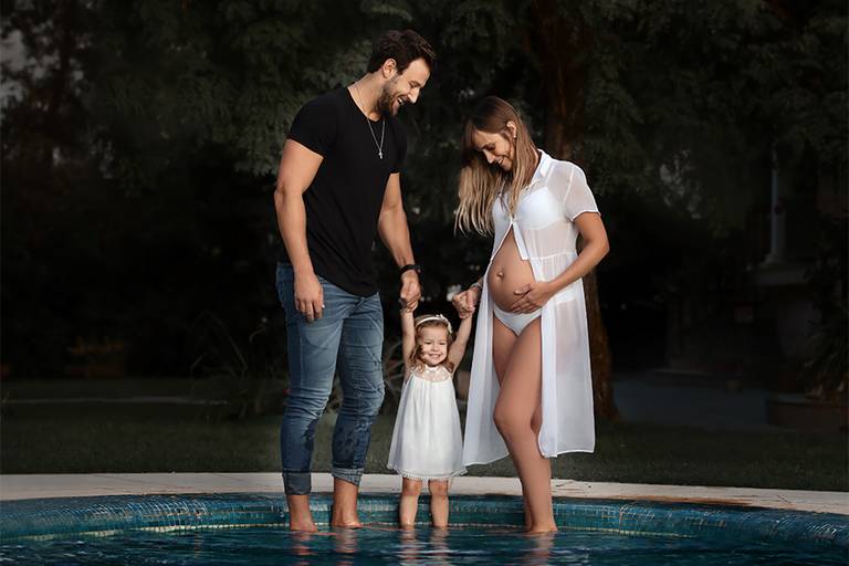 Disfrutando al aire libre, una bella tarde de verano. Mamá, papá y su hermanita. Ellas con sus vestidos blancos y el papá con su jeans y remera negra. Caricias, mimos, y mucha alegría. Barby Massei fotografía en Santa Fe. Sesión familiar. 
