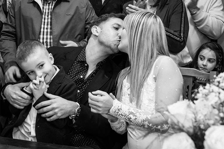Ceremonia civil. Casamiento en Santa Fe. Beso de la pareja con su niño- Foto blanco y negro de Barby Massei.
