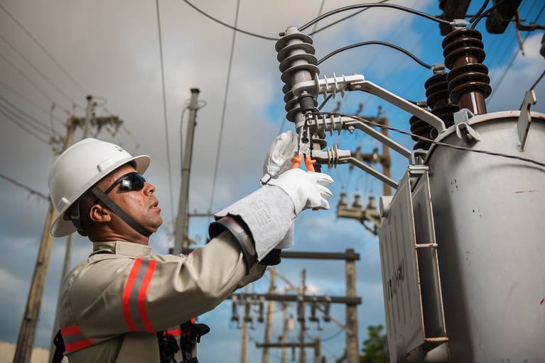 Eletricista no alto do poste consertando um transformador - Fotografia profissional institucional  e corporativa para empresas