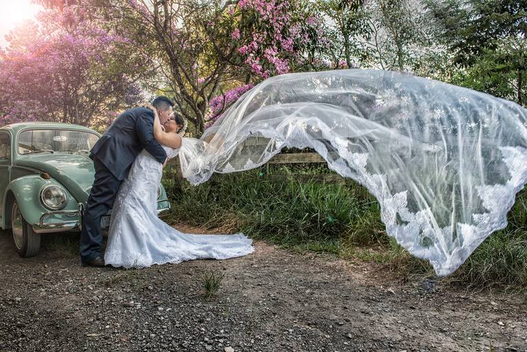 Fotografia de casamento e assim véu voando e carrão ao fundo, fotógrafo Alberto Martinez
