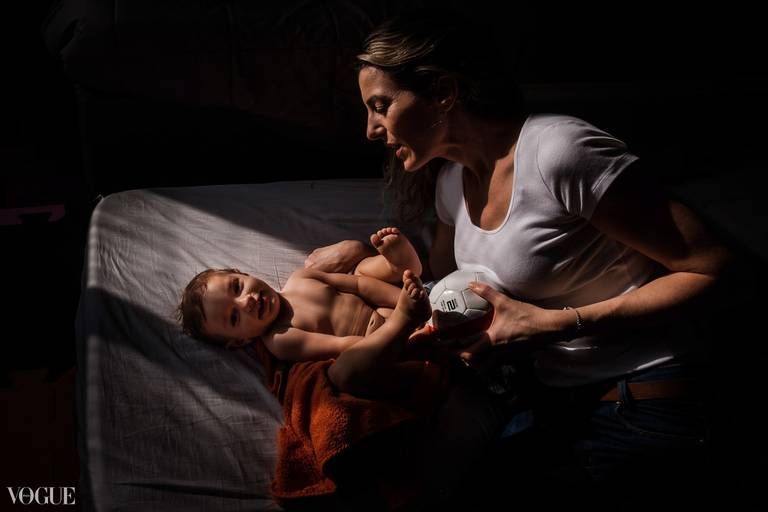 VOGUE mãe com seu filho deitado em um  colchão iluminados com luz de janela 