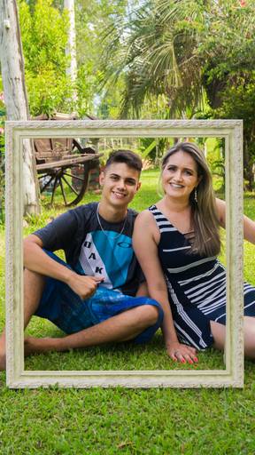 Pousando para foto atrás da moldura a mãe e seu filho adolescente sorriem para a foto de Tiago Costa Fotografia