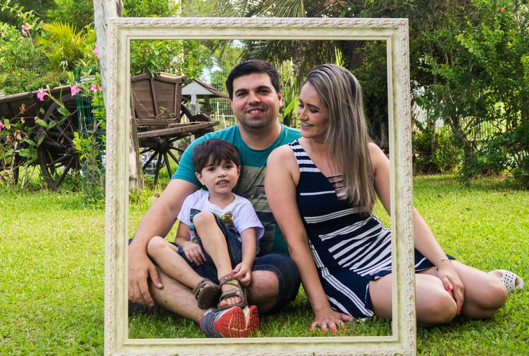 Pai,mãe e filho são fotografados em meio a moldura e a natureza. Tiago Costa Fotografia
