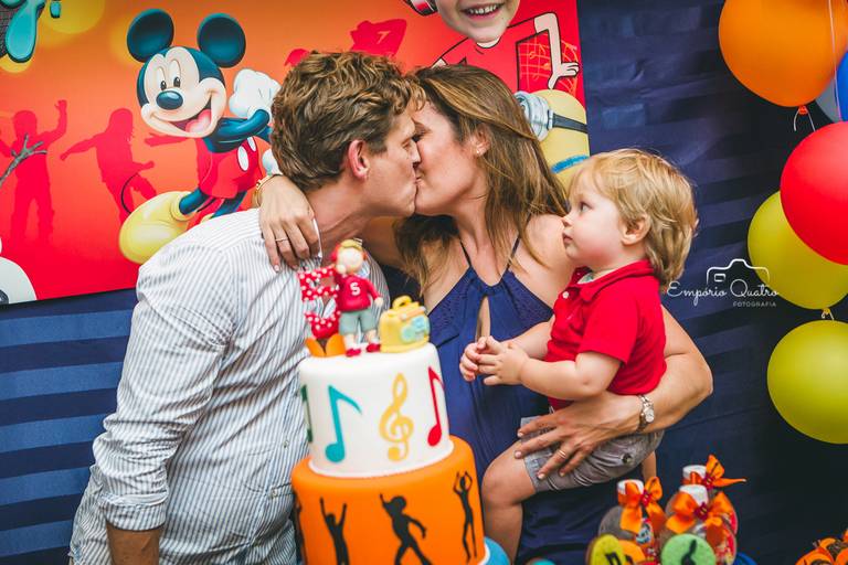 fotografia aniversário pais do aniversariante dando um beijo na mesa do bolo decoração tema dj