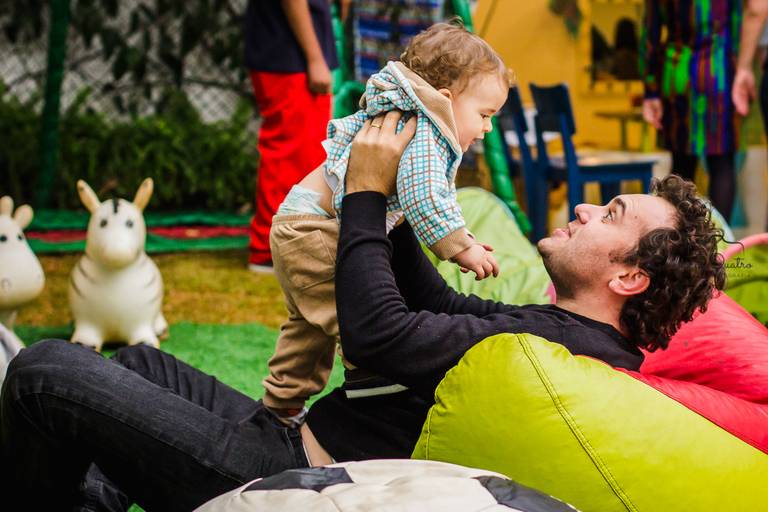 fotografia aniversário bebê sendo levantado pelo pai 