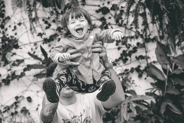 fotografia aniversário criança sorrindo sendo levantada em preto e branco