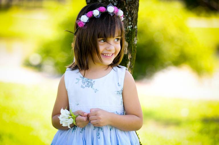 menina sorrindo com flores na cabea