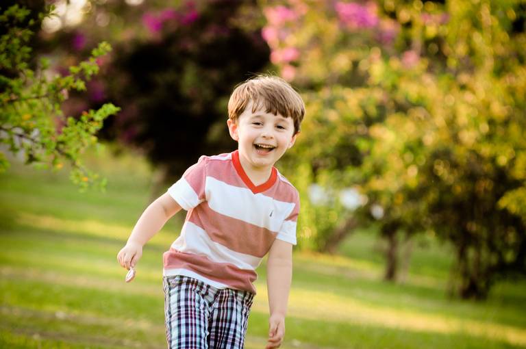 criança sorrindo em ensaio externo