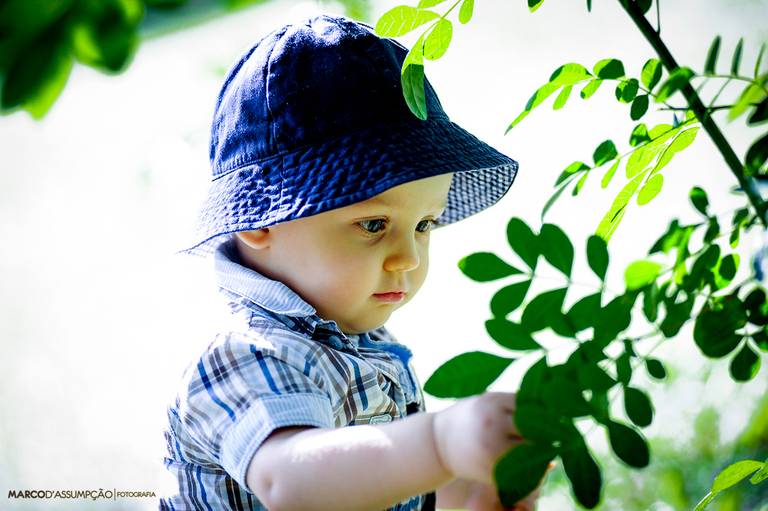 crianca de chapeu olhando as plantas