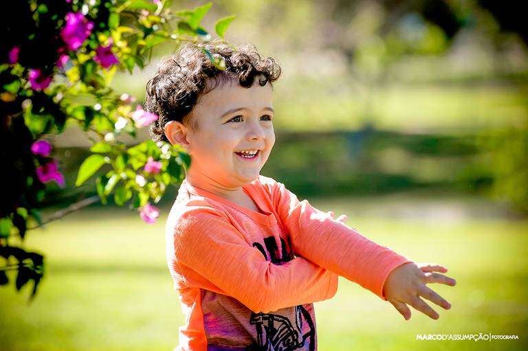 menino sorrindo em jardim