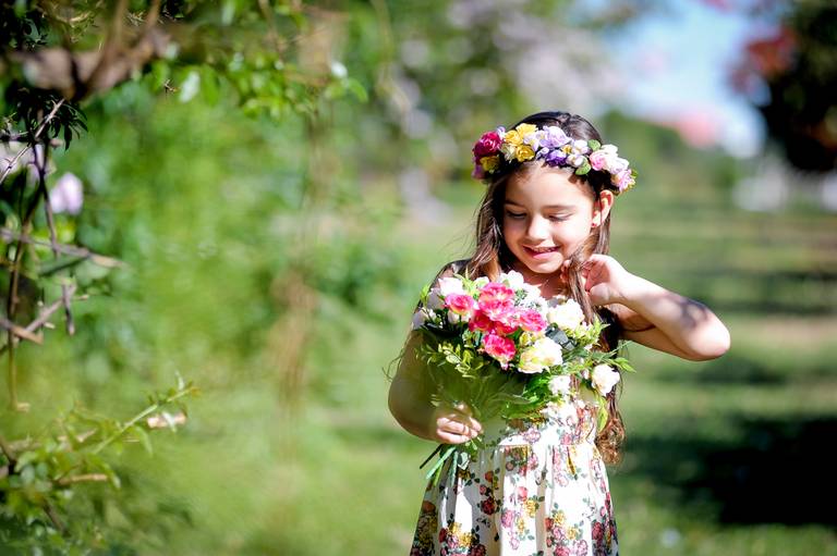 menina fazendo pose com flores na mao